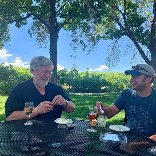 Parker Carlson and Garrett Portra enjoying wine and a snack in the winery backyard